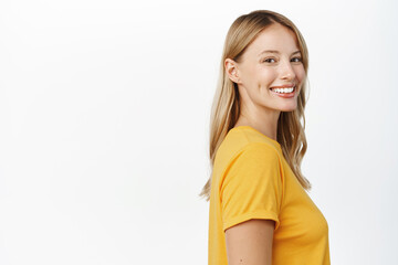 Wall Mural - Portrait of happy modern woman, beautiful girl with white smile, bloind hair and clear natural skin without makeup, standing over white background