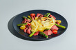 Delicious raclette cheese served over Roast Beef with Tomatoes and Asparagus, dish on white background. Hard light, deep shadow