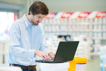 seller assistant choosing laptop computer