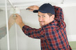 © auremar - young guy repairs video surveillance on a light ceiling