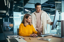 Two Freelancers, An Asian Man And A Woman, Work In A Modern Office, Discussing And Discussing A Joint Project, Looking At A Computer Monitor
