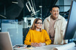 © Liubomir - Business team man and woman, working together, happy and cheerful, looking at a computer monitor, consulting, got a good result of their teamwork