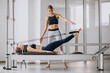 Woman with pilates trainer practising pilates