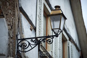 Wall Mural - Closeup of retro street light on medieval house facade in the street