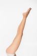 © LIGHTFIELD STUDIOS - partial view of barefoot woman with fit and smooth legs isolated on white