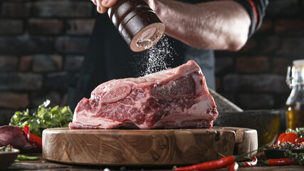 Wall Mural - Close-up of falling salt and pepper on tasty beef steak in kitchen, freeze motion.