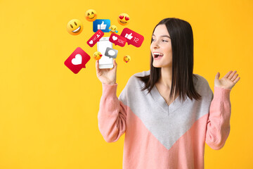 Happy young woman using mobile phone for social networking on color background