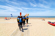 A group of young canoeists with paddles go to the sea for training.