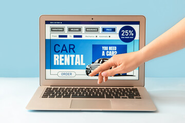 Wall Mural - Female hand and laptop with open page of car rental site on color background