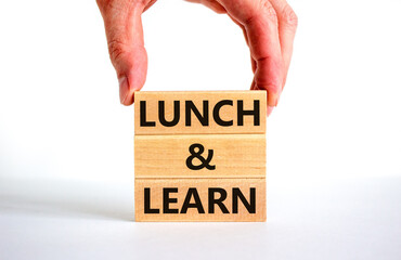 Poster - Lunch and learn symbol. Concept words Lunch and learn on wooden blocks. Beautiful white table white background. Businessman hand. Copy space. Business, educational and lunch and learn concept.