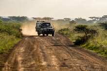 A Typical Safari Vehicle Speeding Along A Dirt Road In Nairobi National Park Near Nairobi, Kenya, Trailing A Cloud Of Dust Behind It