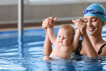 Young Woman Teaching Little Baby How To Swim In Pool