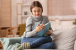 © Pixel-Shot - Beautiful young woman reading book on sofa at home