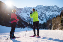 Caucasian Couple Cross Country Skiing One Behind The Other, Making Coordinated Body And Ski Poles Movements.