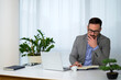 © Route77 - serious young businessman with short stylish beard and glasses sitting at office and taking notes