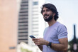 © Buonaventura - View of young man using a smartphone at day time with city view landscape in the background. High quality photo