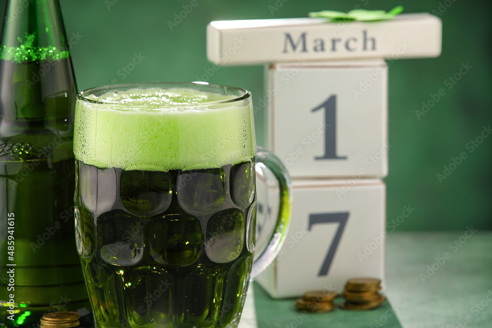 Glass and bottle of beer on green background. St. Patrick's Day celebration