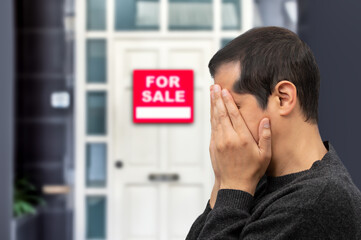 Man extremely depressed and sad about losing his house key and seeing a for sale sign, real estate concept