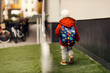 © Dusan Petkovic - Rear view of a kindergarten child with schoolbag on his backs walking outdoors.