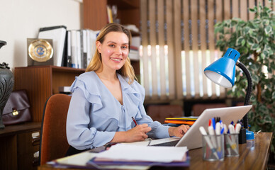 Wall Mural - Successful young business woman using laptop at workplace