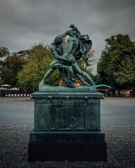 Sticker - A view of the knife wrestlers sculpture against a cloudy sky at Gothenburg, Sweden.