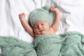 Canvas Print - Cute little baby sleeping under knitted plaid in bed, top view