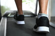 © taveesaksri - legs of person running on treadmill