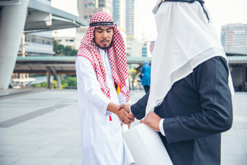 Wall Mural - Arab Businessman Muslim dress shaking hands together. Muslim Men Teamwork business partner handshake with business Partnership. Close up hand UAE diversity multiracial people trust honesty commitment