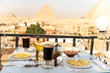 Traveler's breakfast. A table in an outdoor restaurant with a fantastically beautiful view of the great pyramids of Giza. Cairo. Egypt. Romantic dinner on roof with a beautiful view.