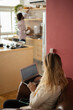 © Buonaventura - Young woman working at home with laptop and papers on desk and headphones. Home office concept.