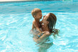 © blackday - Mother and her cute little son swimming in outdoor pool during summer vacation