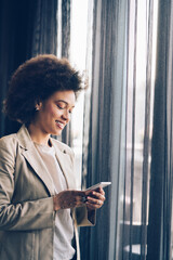 Sticker - Casual beautiful black businesswoman using phone in her office