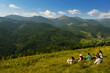 © New Africa - Group of tourists sitting on hill in mountains