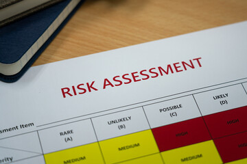 Wall Mural - Risk assessment matrix table paperwork with severity level color for Low, Medium and High. Industrial and business planning object. Close-up and selective partial focus at the text.