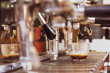 Wall Mural - Close-up of espresso pouring from the coffee machine. Professional coffee preparation