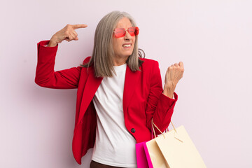 Wall Mural - middle age woman feeling confused and puzzled, showing you are insane. shopping concept