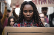 Portrait of a young African woman activist marching during a youth protest - face detail, other remonstrants behind