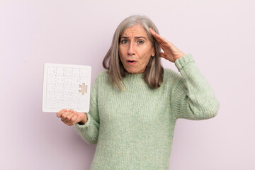 Wall Mural - middle age woman looking happy, astonished and surprised. puzzle challenge concept