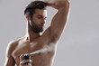© Drobot Dean - Young confident man applying deodorant on his body