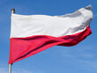 Biało czerwona flaga Polski na błękitnym niebie