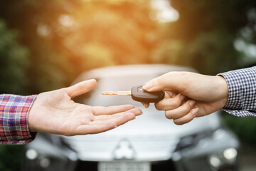 businessman exchange handing over the car keys for to a young women.