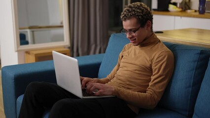 Young man using laptop on the sofa