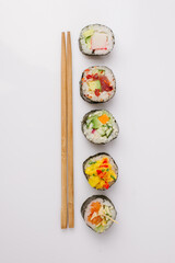 Wall Mural - Maki Sushi Rolls set on wooden board. Japanese traditional Cuisine. White background.