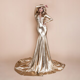 Elegant fashion. Stunning blonde woman in elegant long gold dress