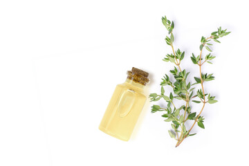 Thyme extract essential oil with fresh thyme herbs isolated on white background. Top view. Flat lay.