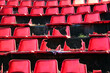 Broken red plastic chairs at an abandoned stadium