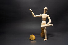 Wooden Figure Mannequin Sitting On A Pile Of Coins Being Happy On A Black Background. Business Concept