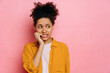 Stunned african american young woman, in casual wear, looking stressed and nervous with hands on mouth biting nails, looking aside, is going through, stands on isolated pink background