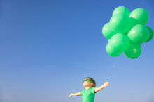 Happy Child With Green Balloons Outdoor