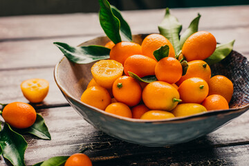 Wall Mural - Fresh kumquat in bowl on wooden background